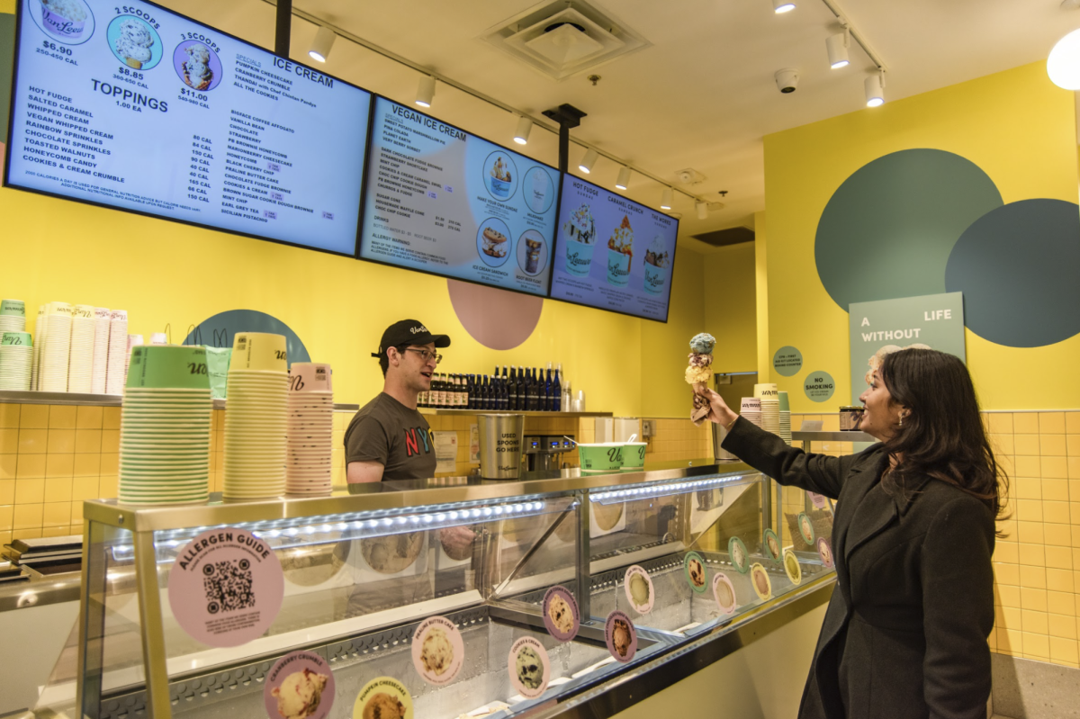 A customer accepts a triple-scoop cone at Van Leeuwens Georgetown location.